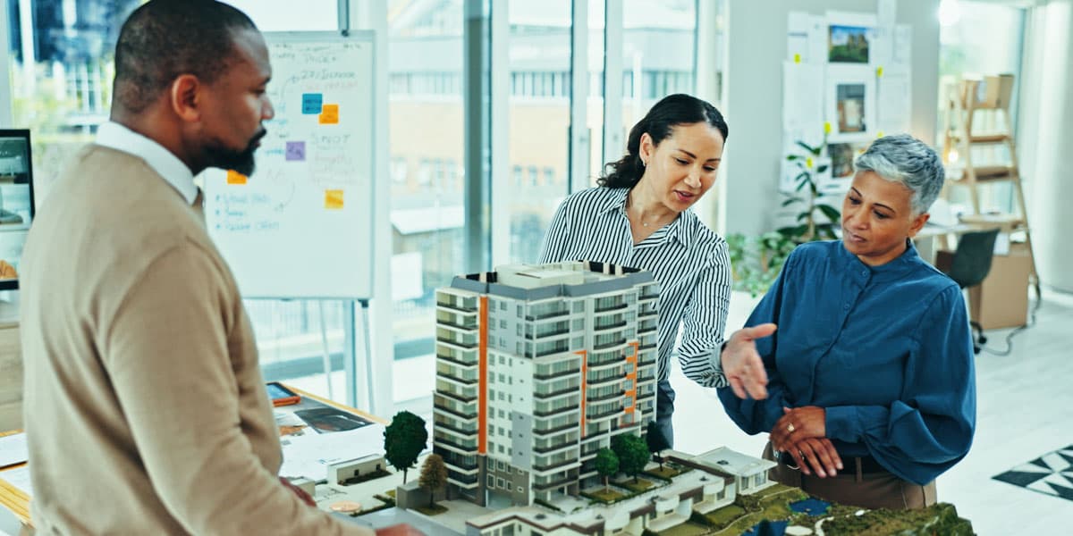 Two women and a man looking over real estate project